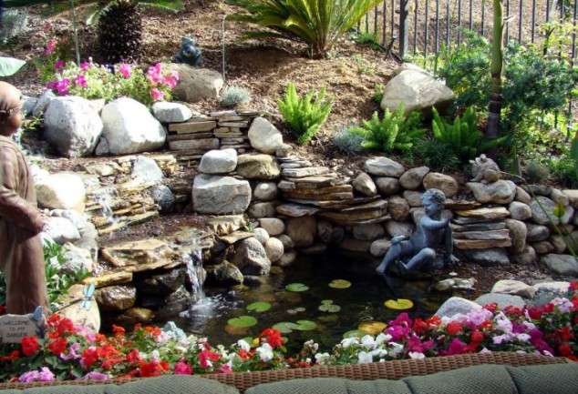 admirable modern garden pond which is decorated with a variety of size and type of natural stone flowers sculpture and waterfalls 725x495 634x433 13 Eye Popping Fountains That Are Absolutely A Must For Every Garden