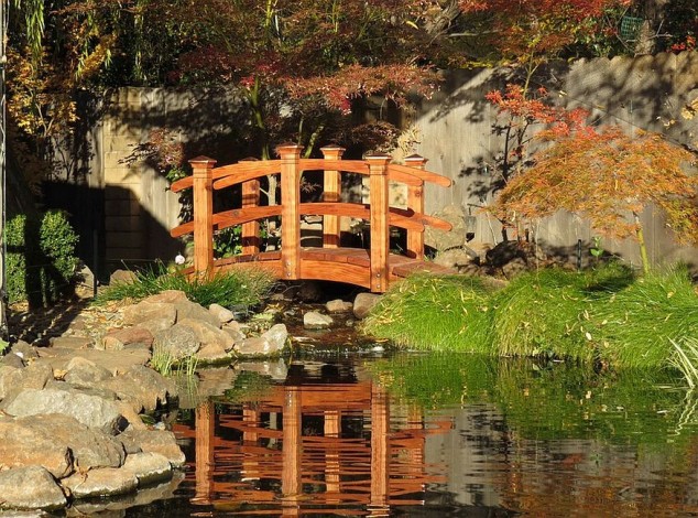 mesmerizing water garden with an arched bridge in oriental style  634x470 21 Brilliant Wooden Garden Bridges That Could Fill The Garden With Beauty And Charm