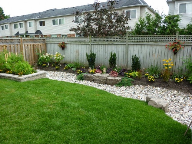 15 Stylish Garden Designs That Use Stones And Rocks garden and patio simple and easy backyard landscaping house design with white gravels rocks stone raised bed various garden plants and sun flowers plus wooden fence ideas simple 634x476 15 Stylish Garden Designs That Use Stones And Rocks
