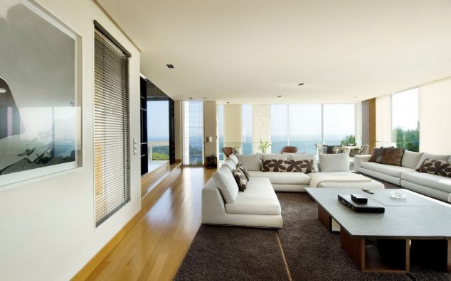 12 Glass Walls Living Room For Luxury Living Deluxe living room sofa set with large table on brown rug along with home theater set with large tv decorated by recessed ceiling lamps and glass wall with shades 634x396 12 Glass Walls Living Room For Luxury Living