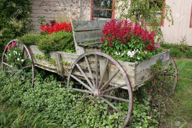 1936029 Wagon flower garden Stock Photo 634x422 10 DIY Ideas How To Use Wagon Wheel In Garden Decor