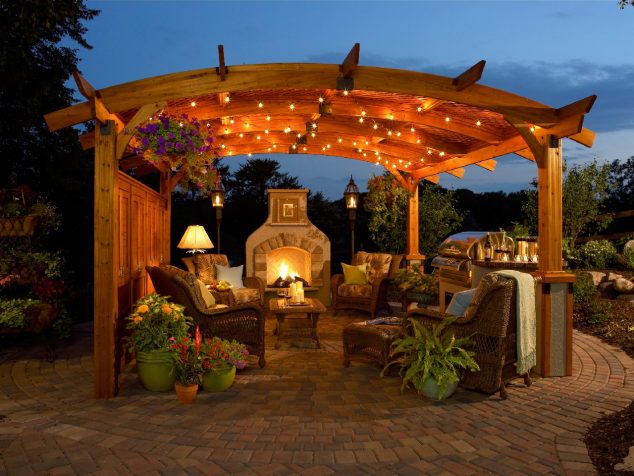 outstanding pergola with curved top and string lighting idea feat modern outdoor stone fireplace plus potted flower plants  634x476 10+ Urban DIY Backyard and Patio Lighting Ideas