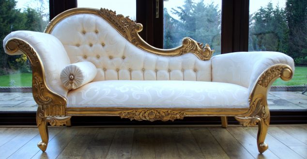 white fabric chaise lounge chairs with tufted back and curvy armrest having carved golden steel frame and base plus rolled pillow on brown wooden floor 634x329 15 Luxury Golden Furniture Ideas To Make Your Day