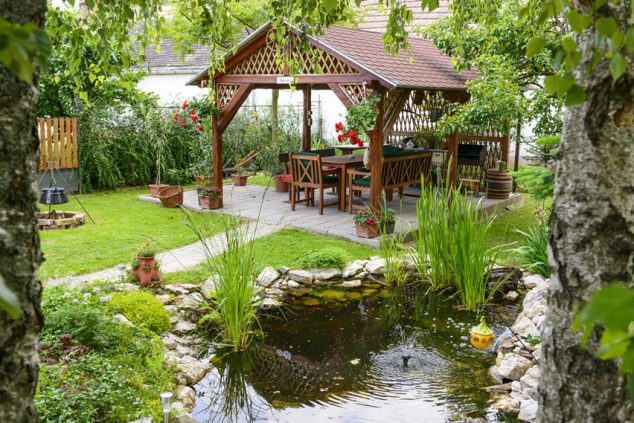 The Most Fanciful Backyard Water Features Ideas backyard water feature pond with outdoor dining canopy 634x423 The Most Fanciful Backyard Water Features Ideas